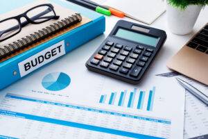 Finanz- und Budgetplanungskonzept mit Taschenrechner, Notizbuch und Finanztabellenbericht auf dem Arbeitstisch