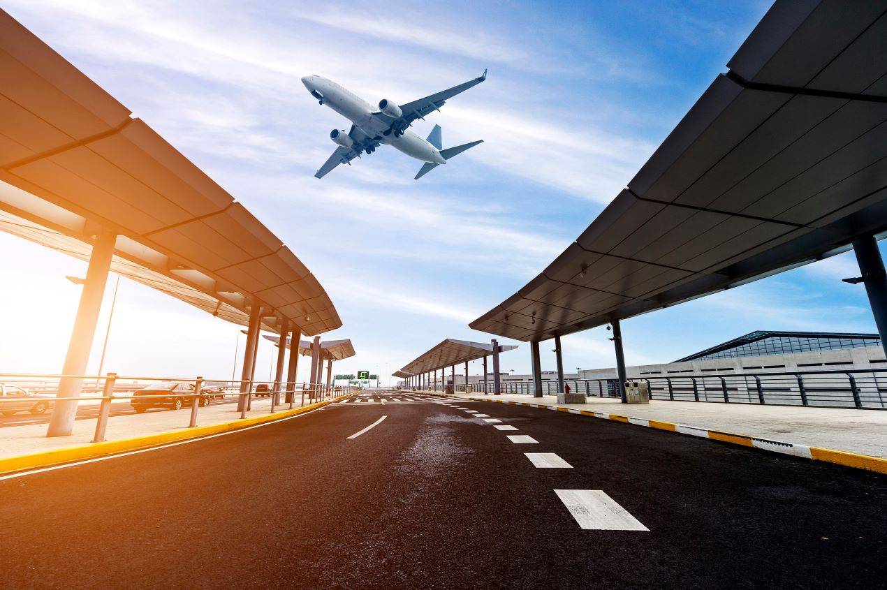 Parken Flughafen Nürnberg: Blick auf das Terminal mit Flugzeug im Himmel, ideal für Abholer und Bringer