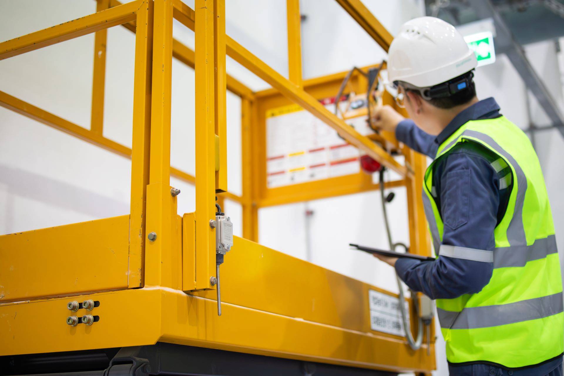 Arbeiter mit Helm prüft Bedienelemente einer Arbeitsbühne in Bocholt